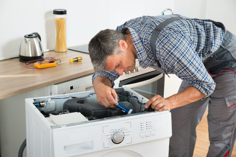 Technician performing professional washing machine repair with diagnostic tools