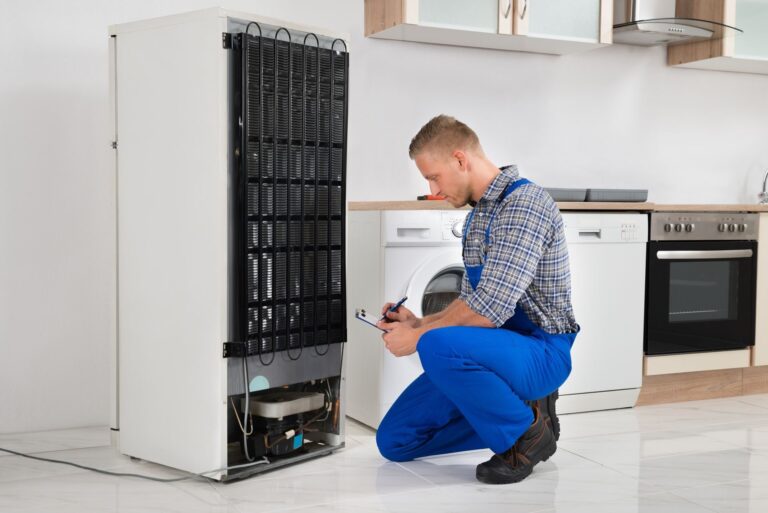 Technician performing professional refrigerator repair service on a residential cooling appliance